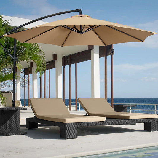 Beige patio umbrella and lounge chairs by a pool with ocean view