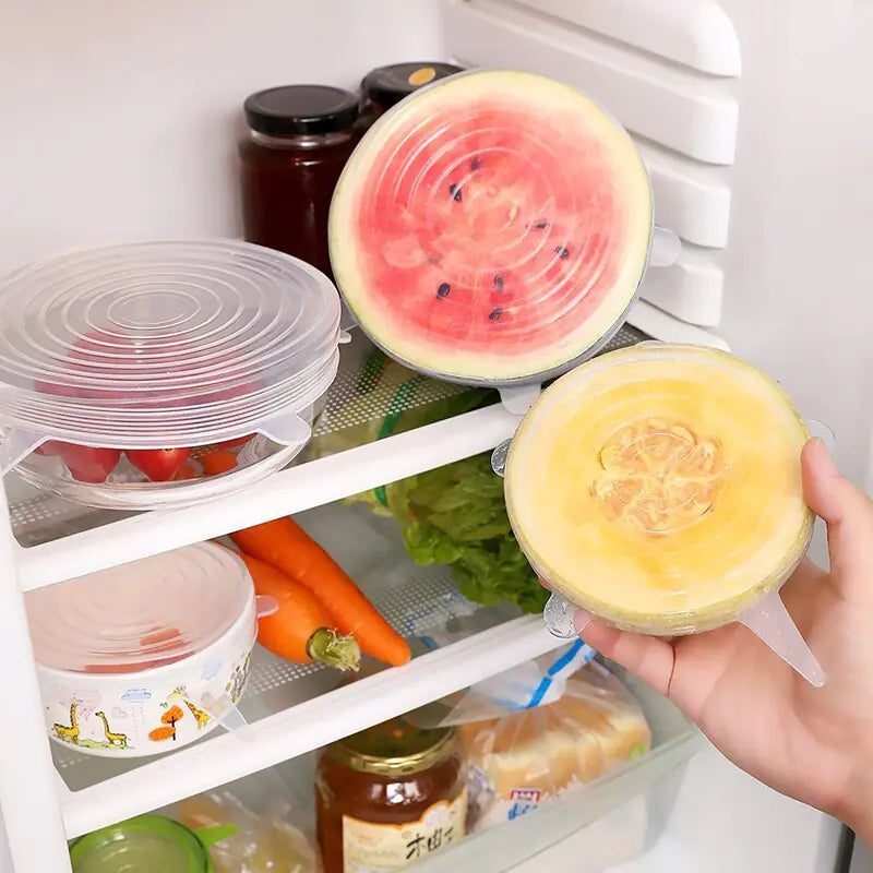 Person holding a round yellow fruit in front of an open refrigerator with food items inside.