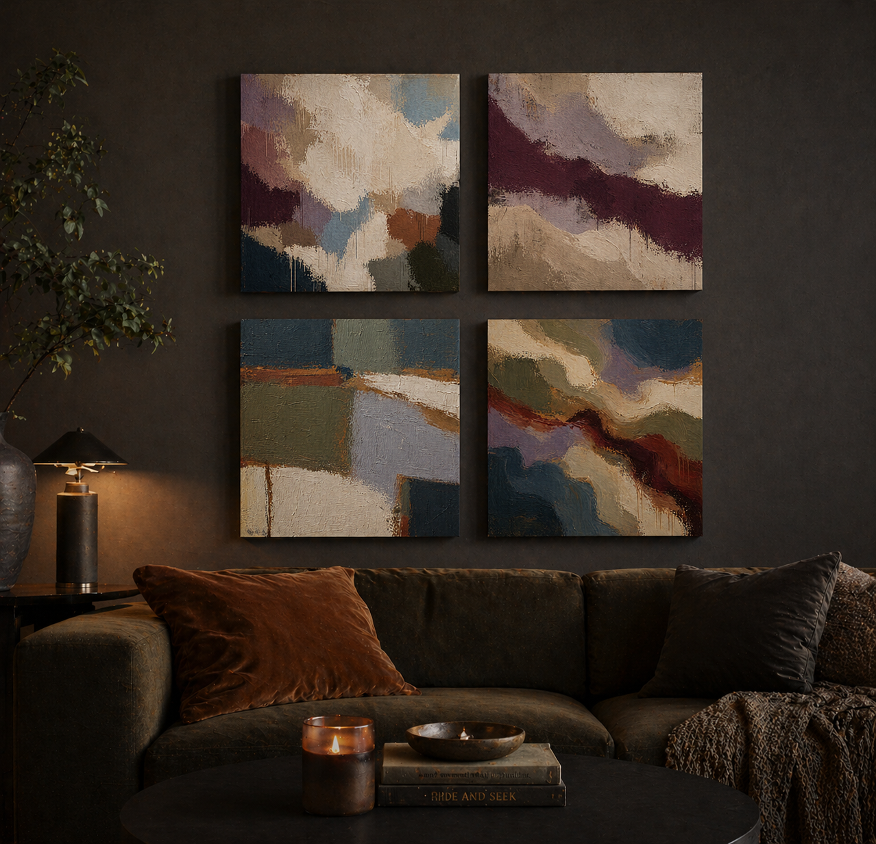Four abstract paintings above a sofa in a dimly lit room.