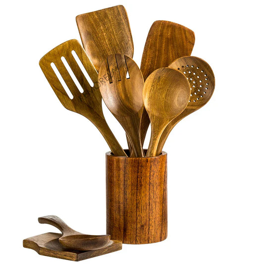 Set of wooden kitchen utensils in a wooden holder on a white background