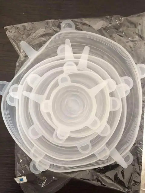 Set of clear silicone stretch lids on a dark surface