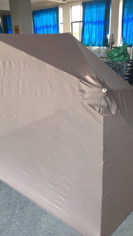 Large beige paper or poster on a stand with blue curtains and indoor plants in the background.