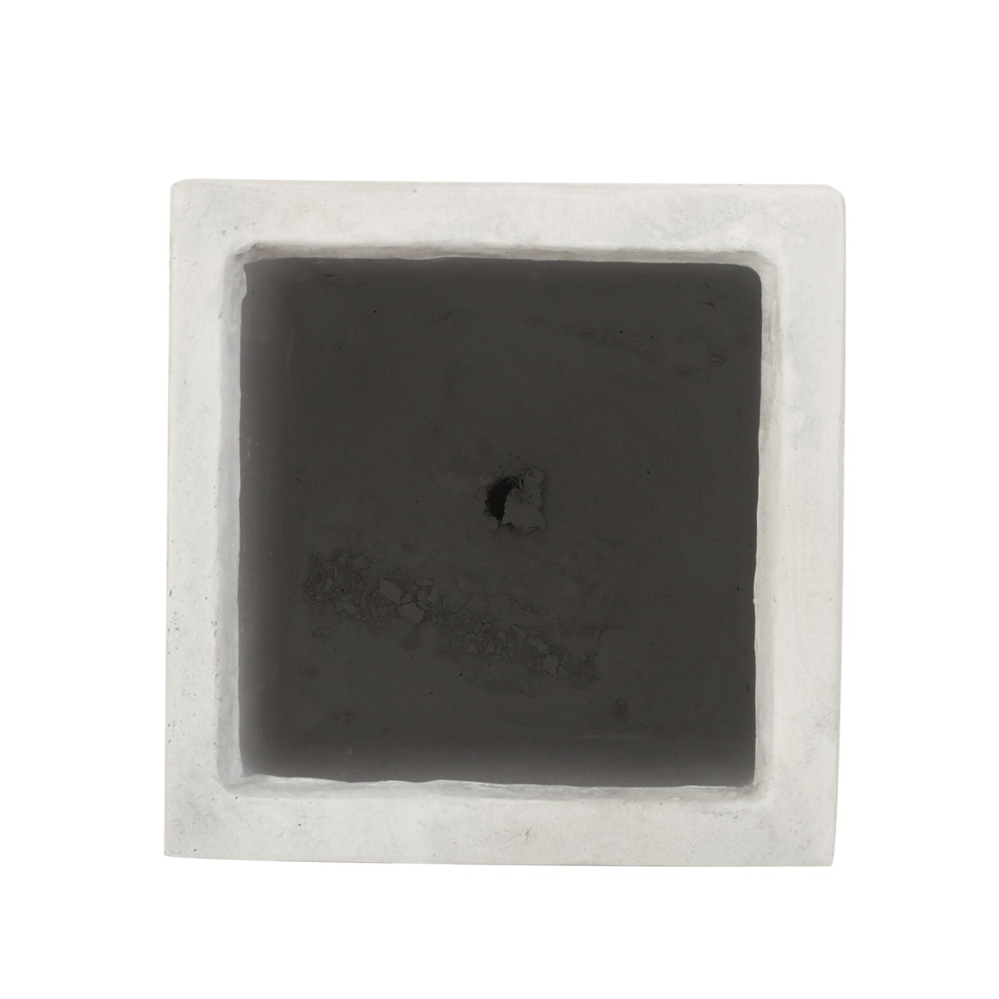 Square black stone with a central hole on a white background