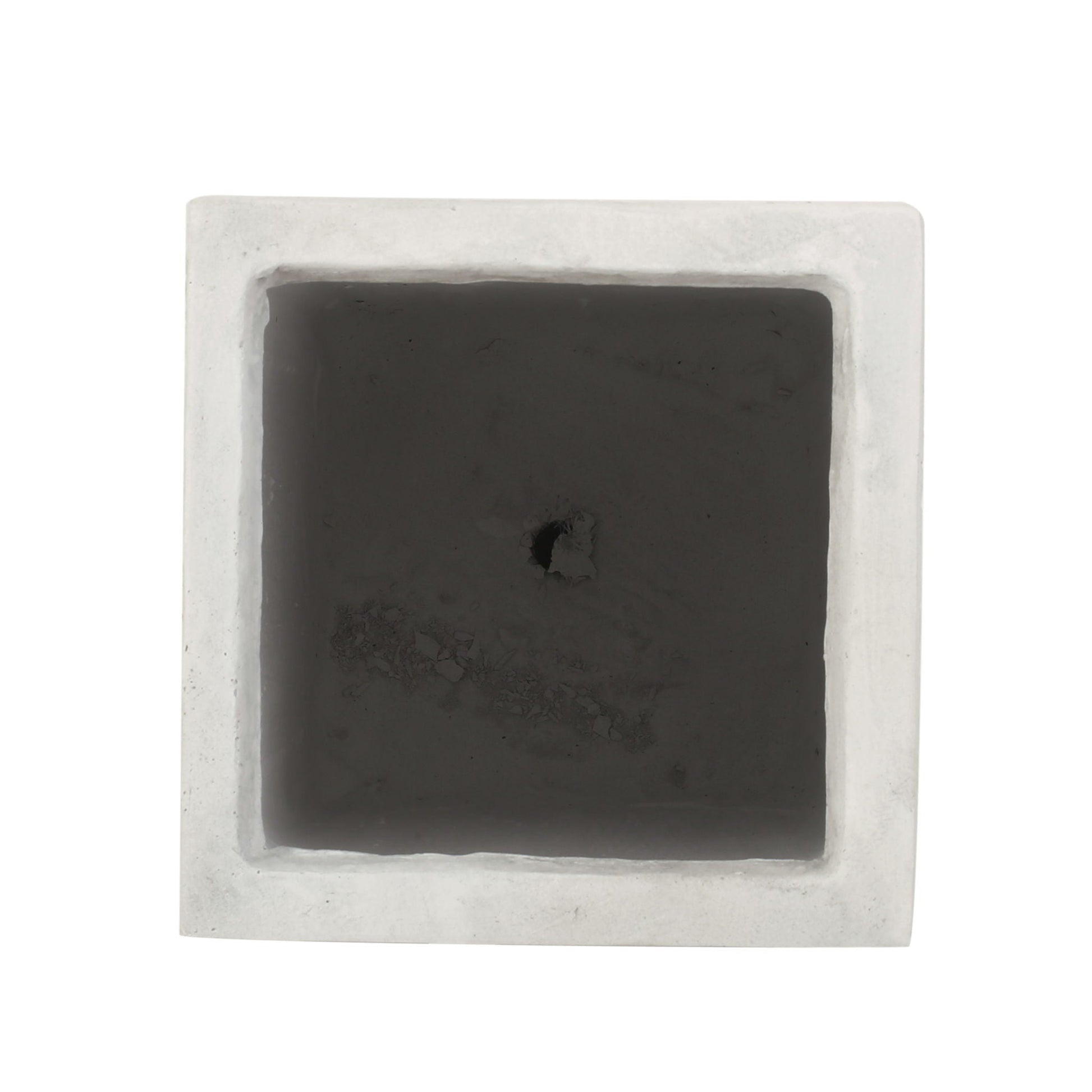 Square black stone with a central hole on a white background