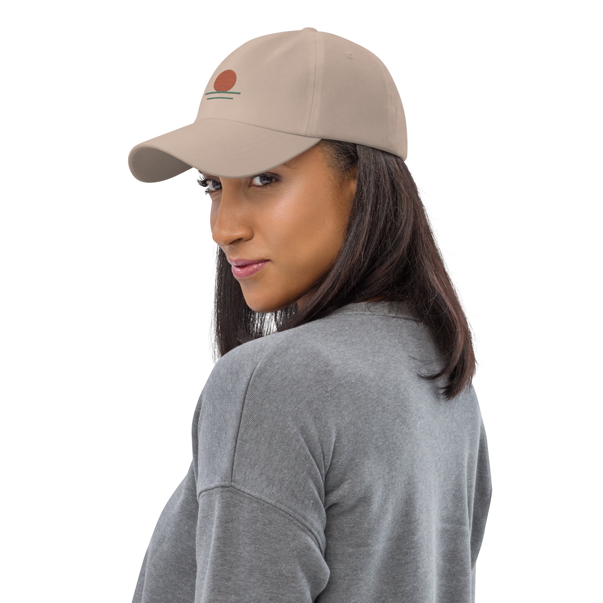 Woman wearing a beige cap with a logo on a white background