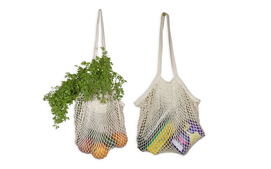 Two mesh bags, one with vegetables and the other with groceries, on a white background